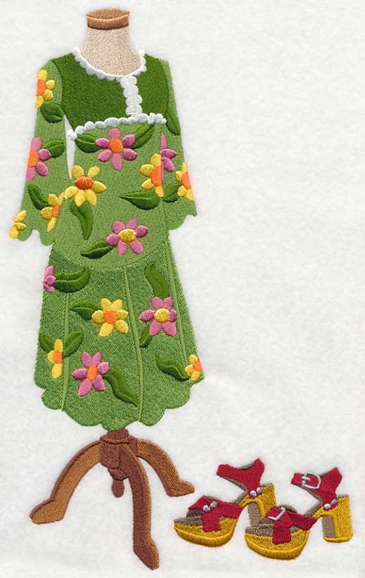 Embroidered green dress with floral patterns on a mannequin, accompanied by red shoes. Made by Not Your Nana, Dunedin, New Zealand