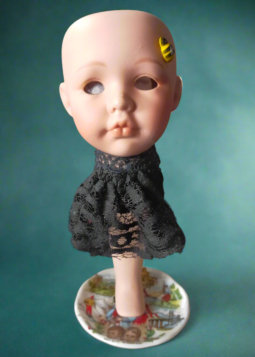Vintage porcelain doll head with bee tea light and black lace dress on a small saucer. Made by Not Your Nana in Dunedin, New Zealand