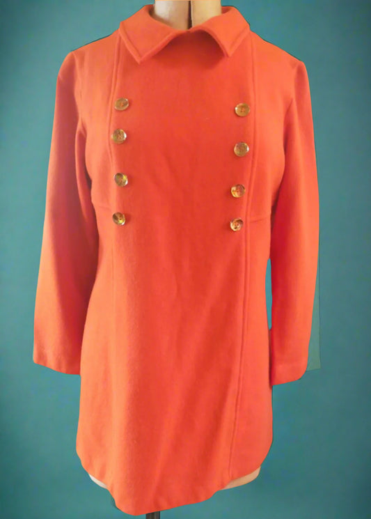 This is a 1960s orange woollen mini dress with a collar and  brass buttons down the front. Found in Dunedin, New Zealand