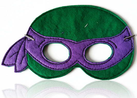 This is a green Teenage Mutant Ninja Turtle mask. Made by Not Your Nana in Dunedin, New Zealand.