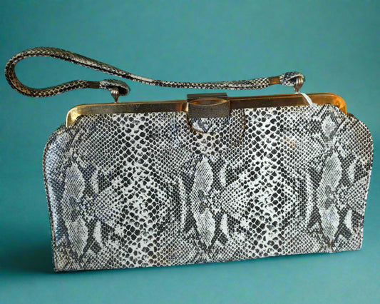 Snake print clutch bag with a gold clasp on a white background
