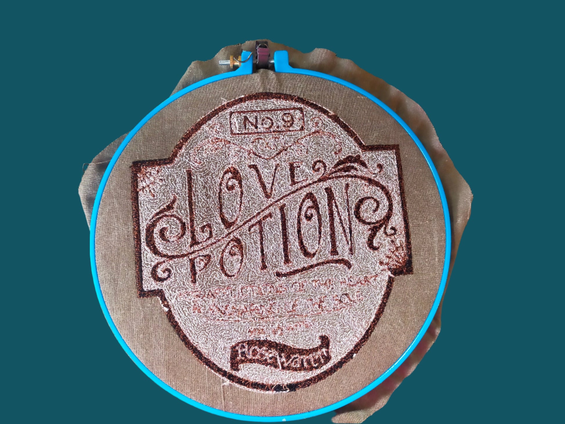 This is a sepia embroidery of a bottle label with the word s Love potion number 9. Made by ot Yout Nana ind Dunedin, New Zealand