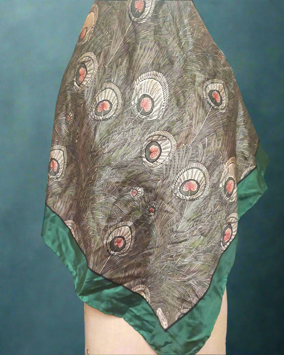 This is a beautiful, luxurious Liberty silk scarf in green and grey. The fabric design is that of peacock feathers in a green and gry colourway