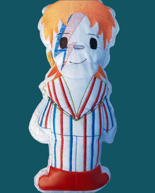 This is a stuffie of David Bowie, wearing his famous striped pantsuit and red boots. It is suitable for all ages. Made by Not Your Nana in Dunedin, New Zealand
