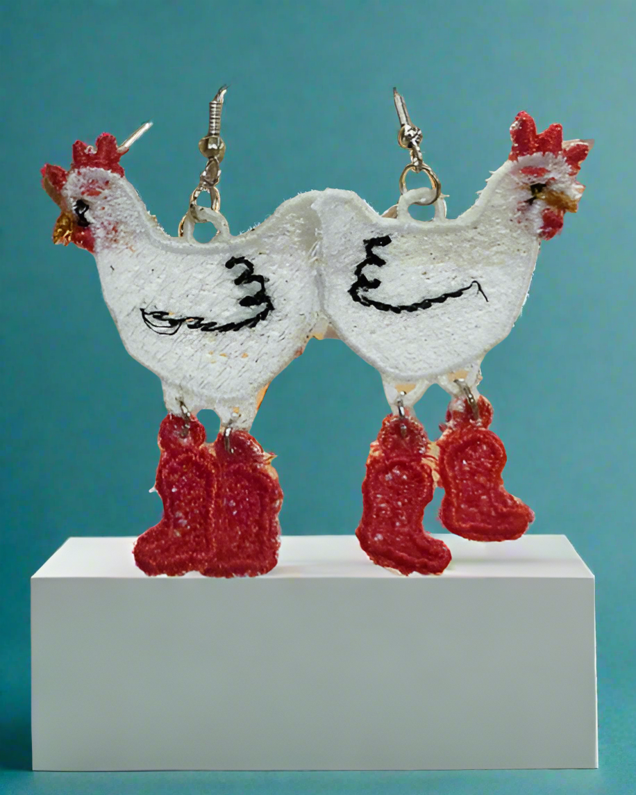 Chicken-shaped earrings on a display card with a teal background