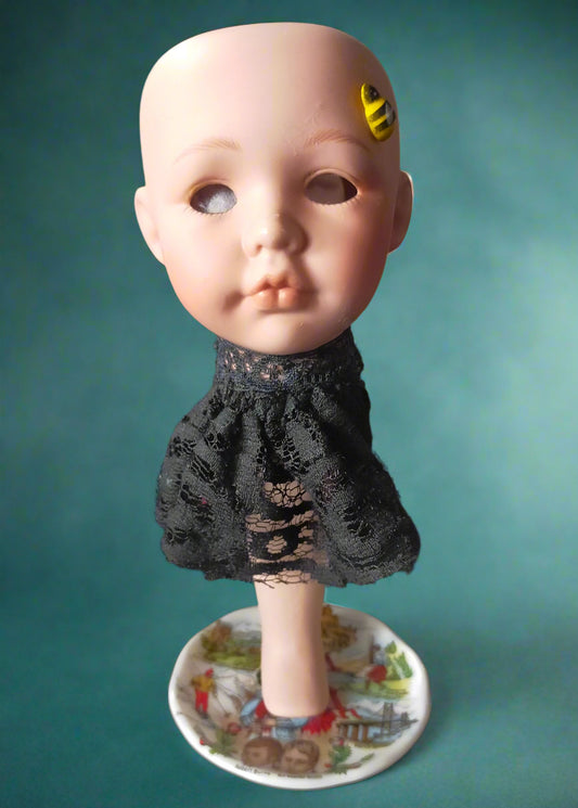 Vintage porcelain doll head with bee tea light and black lace dress on a small saucer. Made by Not Your Nana in Dunedin, New Zealand