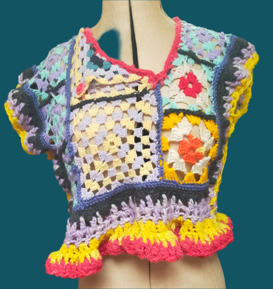 This is a mixd yarn hndmade crochet crop top. The asymmetic neckline is held with a pinkk vintage button. The edings and frill are crocheted from achunky handmade, hand dyed 100% wool. Made by Not Your Nana, Dunedin, New Zealand