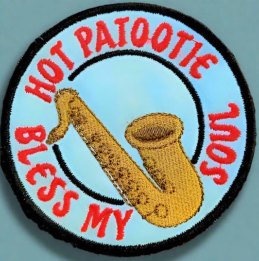 This patch has a picture of a saxophone  and the word "hot patootie bless my soul" embroidered on it, referring to a quote from "Rocky horror picture show".  Made by Not you nana in Dunedin, New Zealand.