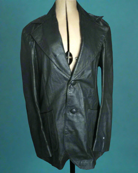 This is a longline 1970s black leather jacket. I has wide lapels and fastens with 2 leather covered buttons. Found by Not Your Nana in Dunedin, New Zealand