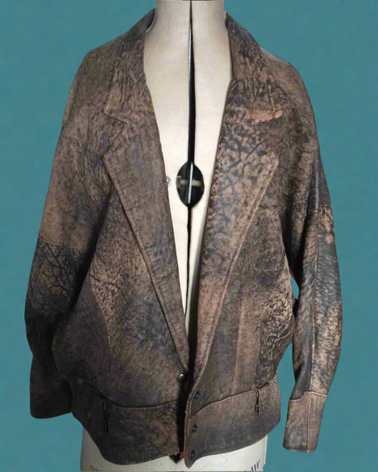 This is a distressed brown leather jacket from the 1980s.  Is long with a band at the bottom. Found by Not Your Nana in Dunedin, New Zealand