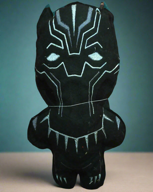 This is a black and grey plush toy . Made by Not Your Nana in Dunedin, New Zealand