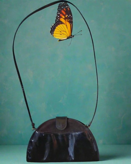 This is a small semi circular Juna bag with a long thin strap. It is black an made from patent and suede leather. Found by Not Your Nana in Dunedin, New Zealand