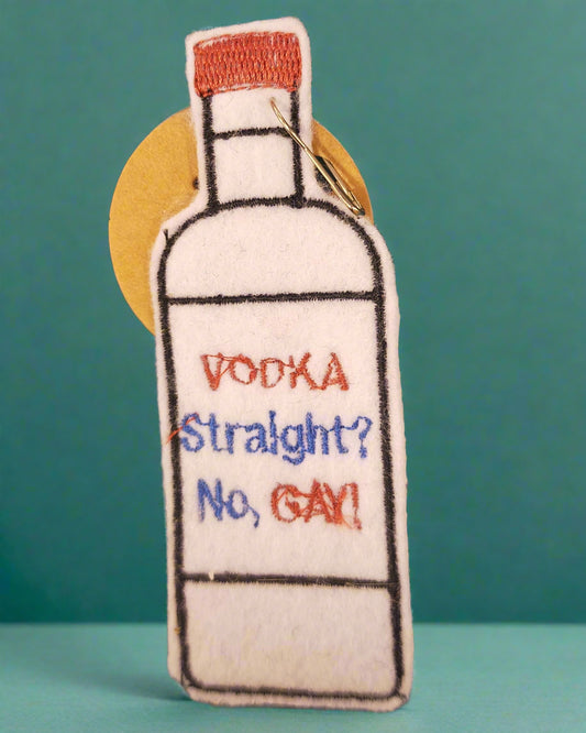 Embroidered patch of a vodka bottle with text on a textured fabric background