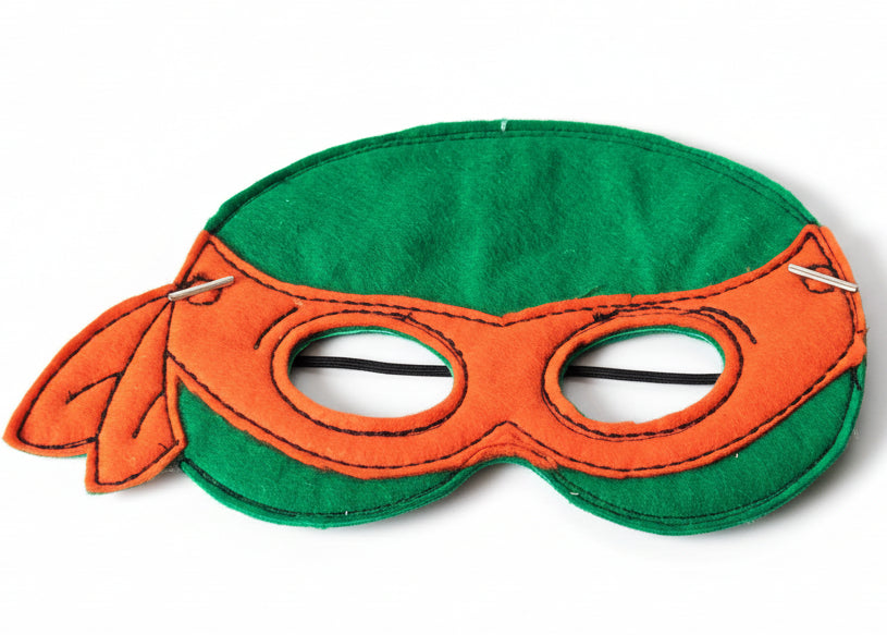 This is a green Teenage Mutant Ninja Turtle mask. Made by Not Your Nana in Dunedin, New Zealand.