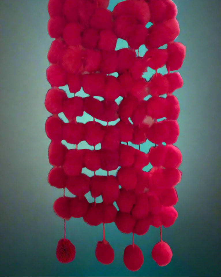 This is a red possum pompom scarf made by Seriously Twisted of Dunedin. Found by Not Your Nana.