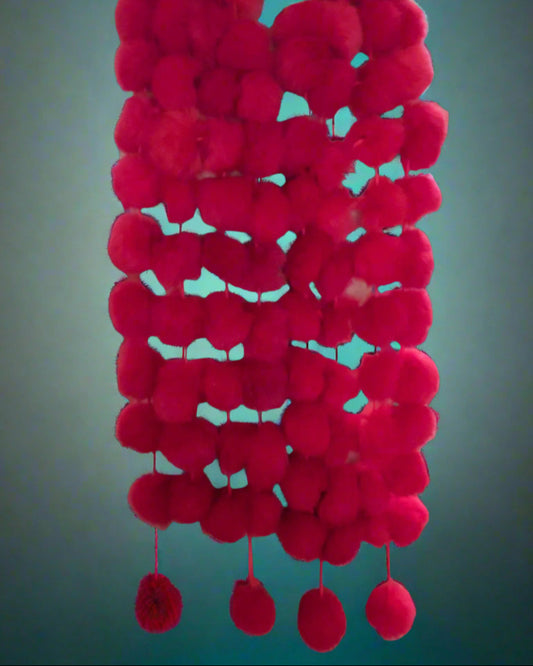 This is a red possum pompom scarf made by Seriously Twisted of Dunedin. Found by Not Your Nana.