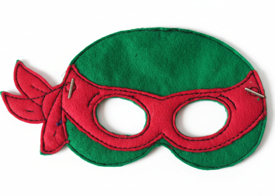 This is a green Teenage Mutant Ninja Turtle mask. Made by Not Your Nana in Dunedin, New Zealand.
