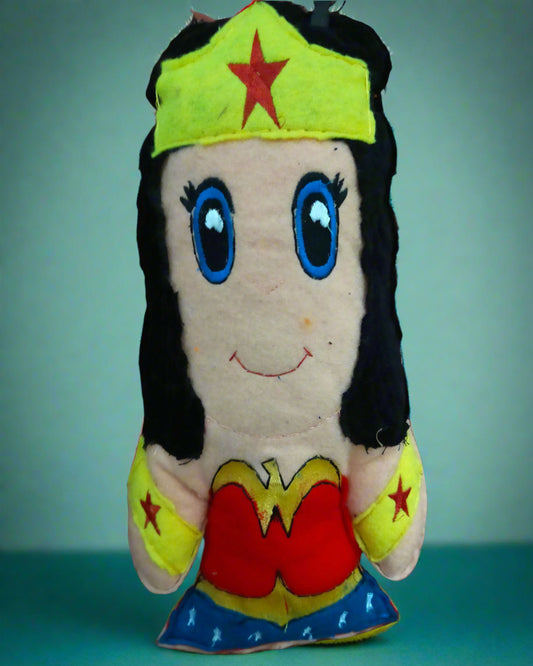 Plush toy resembling a superhero character on a tiled floor