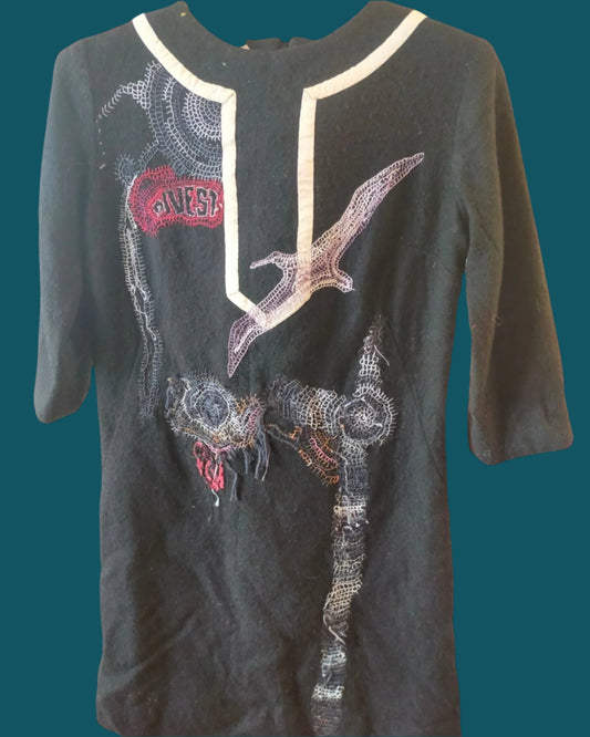 This is a short woollen dress with 3/4 sleeves. It is hand embroidered with an albatross and an oil slick. Made by Made your Nana in Dunedin, NZ