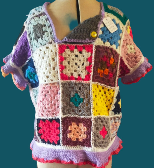 This is a multi-coloured crocheted peggy square top with an interesting neckline.  Made by Not Your Nana in Dunedin, New Zealand.